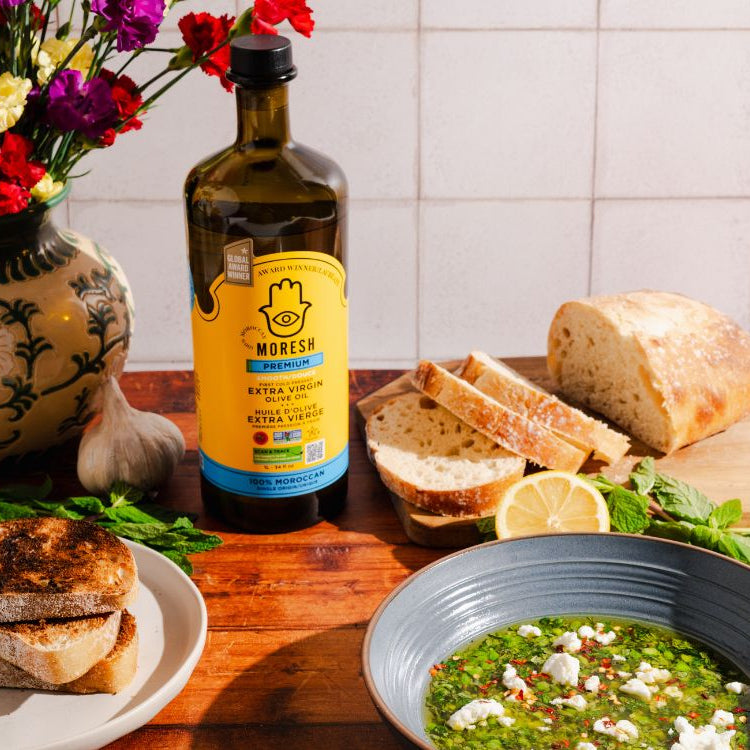  Bowl of Moresh extra virgin olive oil snap pea and mint dip surrounded by slices of crusty bread, ready for dipping.